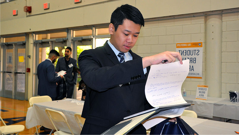 Student looking a papers on clipboard